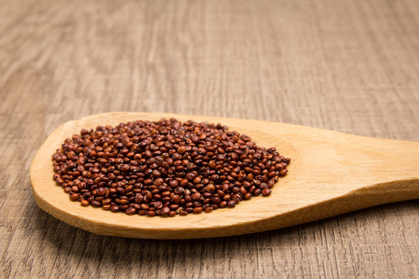 Chenopodium quinoa - научное название семечка Red Quinoa. Зерна в деревянной ложке. Сельский
. - Фото, изображение