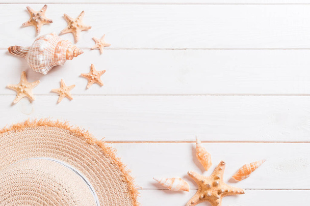 Summer holiday background with straw hat and seashells on wooden background top view with copy space. - Foto, Imagem