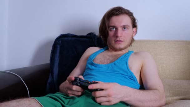 Concentrated young man playing video game at home - 映像、動画
