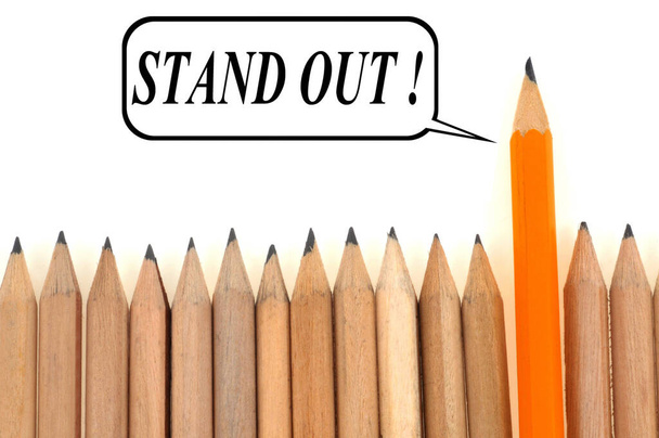 Stand out written next to pencils lined up close up on white background - Photo, Image