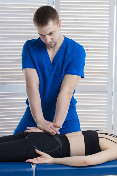 The chiropractor diagnoses the patient. The doctor makes the diagnosis of the woman tone of spinal muscles - Photo, Image