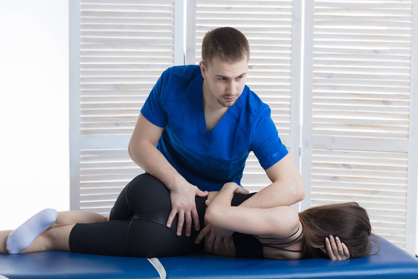 The chiropractor diagnoses the patient. The doctor makes the diagnosis of the woman tone of spinal muscles - Photo, Image