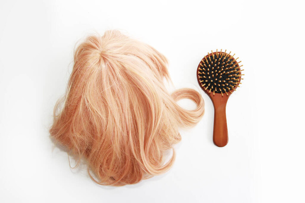 spoiled curls hair blonde wig and wooden brown massage a comb - Zdjęcie, obraz