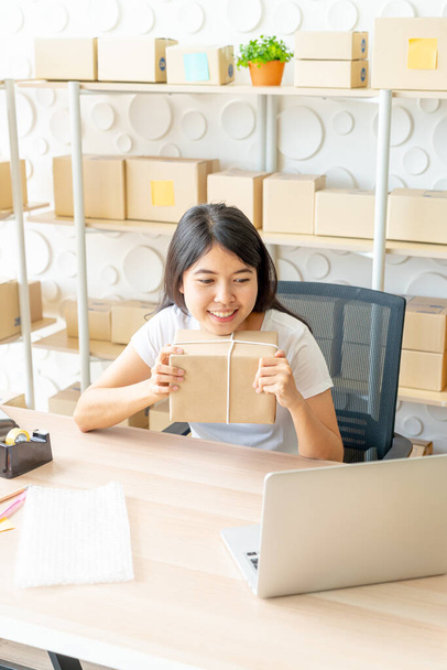 Asian Women business owner working at home with packing box on workplace - online shopping SME entrepreneur or freelance working concept - Foto, Bild