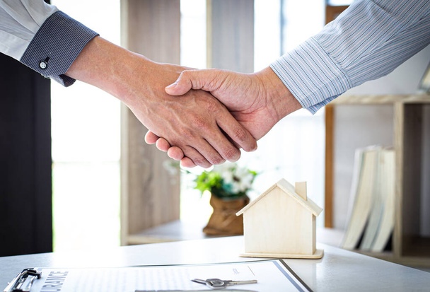 Mindkét üzletember kezet fog, hogy gratuláljon nekik a lakásbiztosítással, lakásvásárlással és biztosítással kapcsolatos szerződés sikeres aláírásához.. - Fotó, kép
