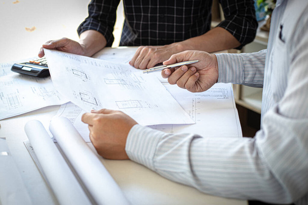 Engineers or architects are meeting a team to design the architectural structure in the design with blueprints and model buildings in working site, Technological structure and construction Concept. - Photo, Image