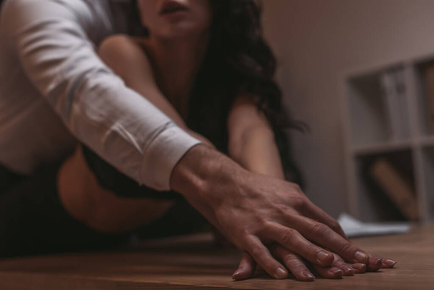 обрізаний вид бізнесмена обіймає сексуальну секретарку і торкається її руки
 - Фото, зображення