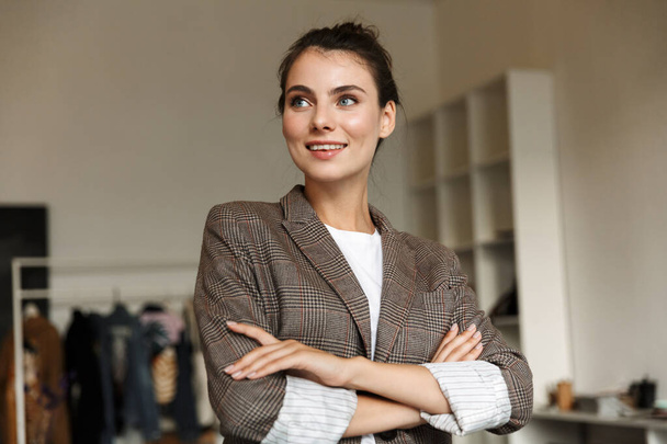 Attractive confident young woman designer standing at the office, arms folded - Foto, Imagem
