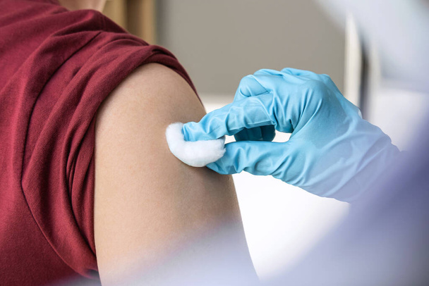 Az orvos az injekció beadását beteggé teszi a betegség, influenza vagy influenzavírus világjárvány megelőzésére a klinikán. - Fotó, kép