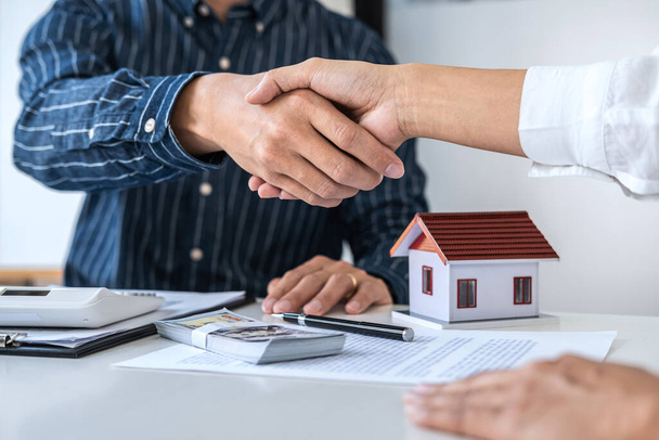 Агент по недвижимости и клиенты пожимают друг другу руки, отмечая завершенный контракт после подписания договора о жилищном страховании и инвестиционном кредите, рукопожатии и успешной сделке. - Фото, изображение