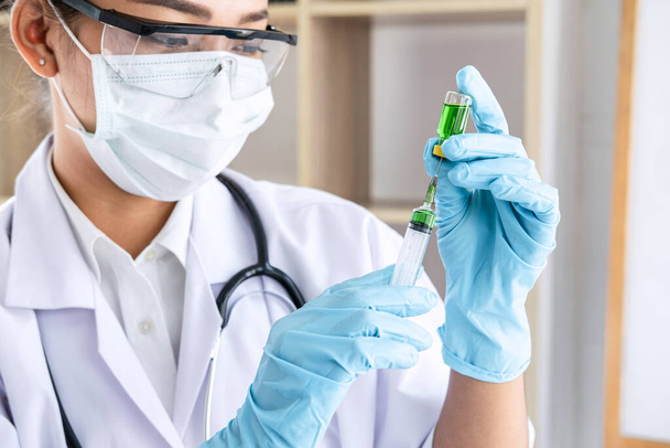Doctor hand holding syringe and vaccine in blue gloves to prepare prevent pandemic of the disease, flu or influenza virus. - Foto, Bild