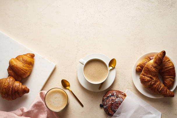 coffee and croissants on table. Breakfast in bakery concept - Фото, изображение