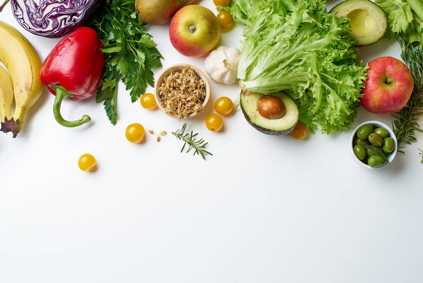 Set aus gesundem rohem Bio-Gemüse mit Kräutern und Sprossen mit Früchten isoliert auf weißem Hintergrund, Draufsicht, vegetarisches Ernährungskonzept  - Foto, Bild