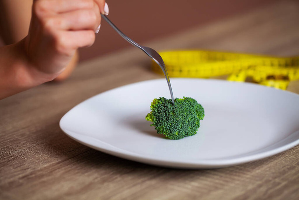 Concepto de mujer con sobrepeso comiendo dieta de brócoli
 - Foto, imagen