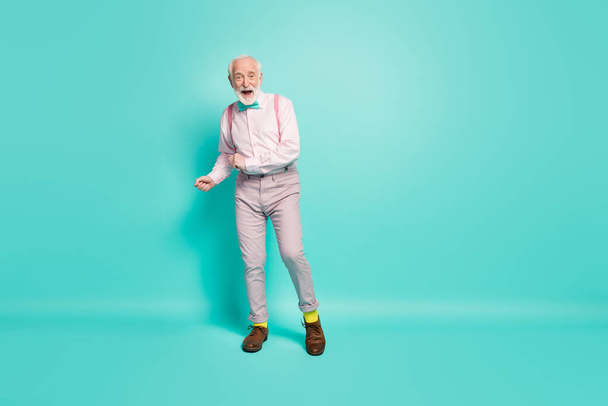 Full size photo of excited crazy retired old man want enjoy vintage discotheque dace dancer wear pink bowtie shoes grey pants isolated over teal color background - 写真・画像