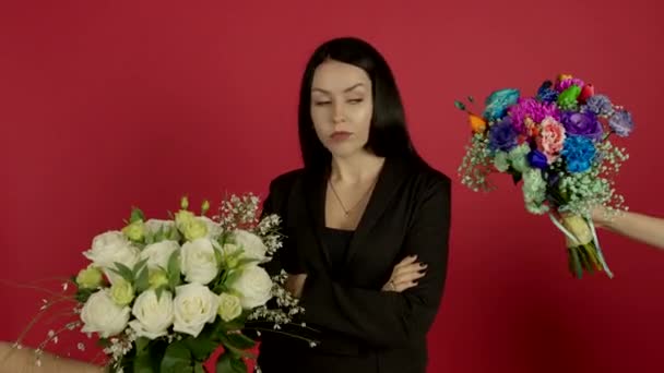 Confident bunette woman standing with crossed arms and choosing flowers - Felvétel, videó