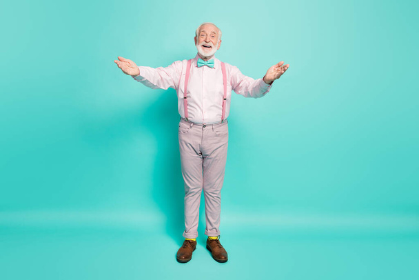 Foto de longitud completa de divertido abuelo mantenga los brazos abiertos buen humor quiere abrazar a los nietos que se reúnen desgaste camisa rosa tirantes lazo pantalones aislados color verde azulado fondo
 - Foto, imagen