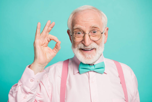 Closeup photo of amazing grey haired grandpa showing okey symbol express agreement wear specs pink shirt suspenders bow tie isolated bright teal color background - Φωτογραφία, εικόνα