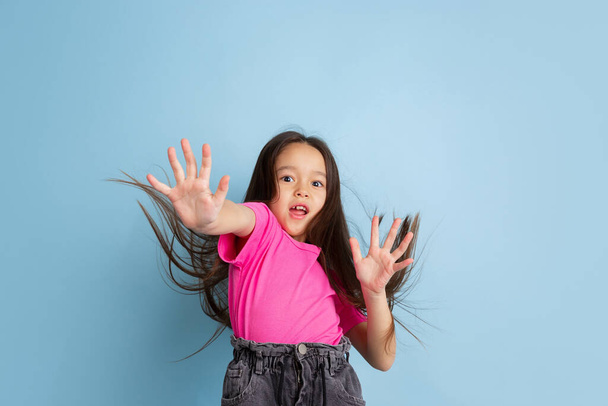 Caucasian little girls portrait on blue studio background - Foto, Imagen