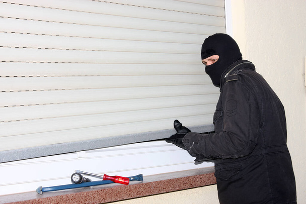 Burglar en sombrero negro con cortina - Foto, Imagen