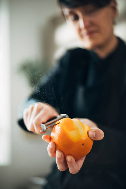 Chef peeling orange in the kitchen - Fotografie, Obrázek