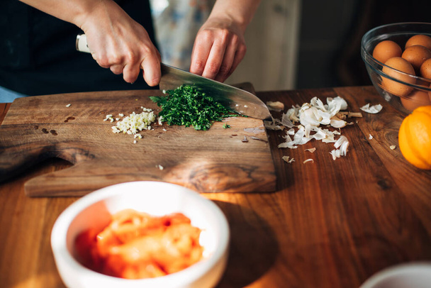 Chef chopping parsley with knife on a wooden board - Zdjęcie, obraz