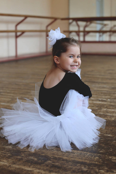 маленька балерина сидить на підлозі в балетному класі і насолоджується перервою
 - Фото, зображення