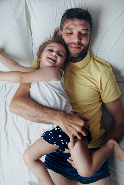 Father and daughter playing on bed - Foto, immagini