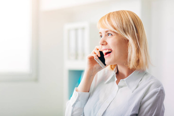 Woman Manager at the Office receiving good news on the phone - Фото, изображение