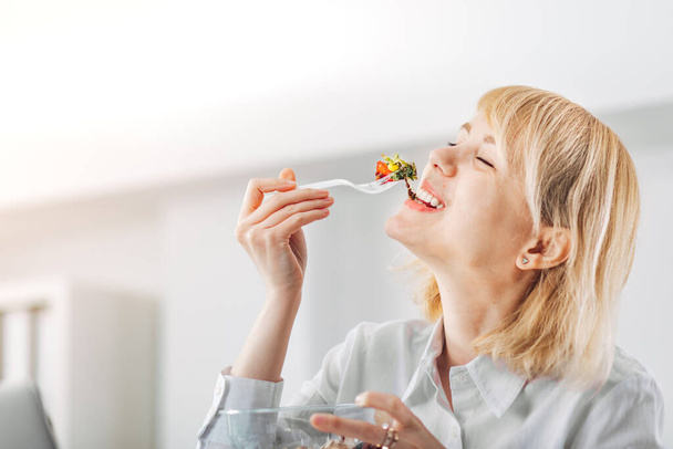 Close up of a Woman in the office eating a salad - Foto, imagen