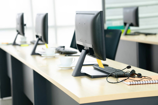 Вид збоку на стільці комп'ютери і гарнітура в сучасному офісі або навчальному центрі
 - Фото, зображення
