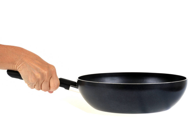 Τηγάνι τηγανίσματος στο ένα χέρι κοντά σε λευκό φόντο  - Φωτογραφία, εικόνα