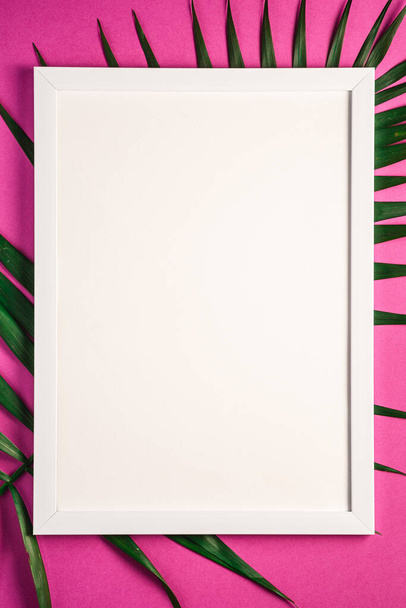 Cadre photo blanc avec gabarit vide sur les feuilles de palmier, fond violet rose, carte maquette
 - Photo, image