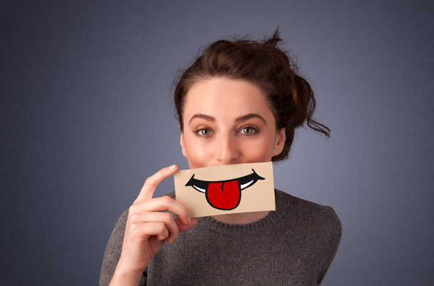 Happy pretty woman holding card with funny smiley - Photo, Image
