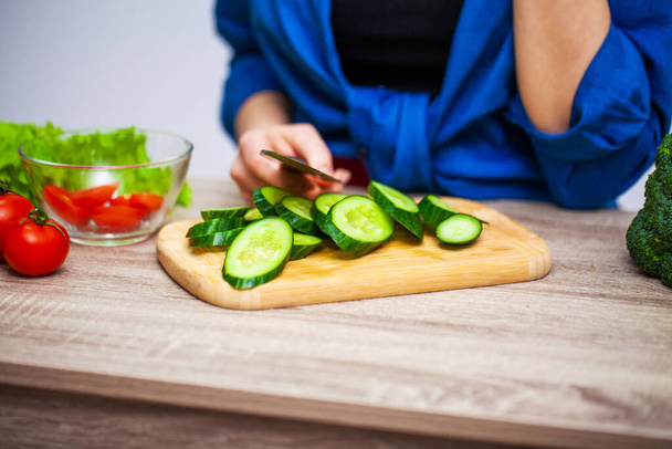 Conceito de alimentação saudável, mulher corta legumes frescos para salada
 - Foto, Imagem