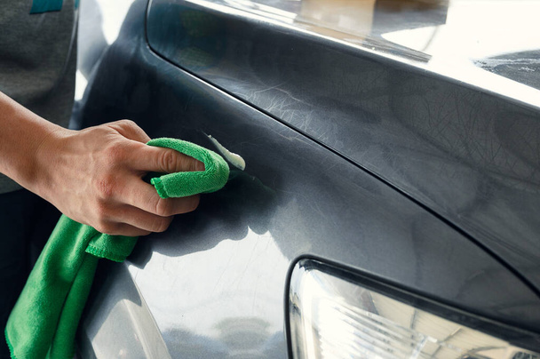 Férfi tisztító karcolás autó zöld mikroszálas ruha és tisztább eltávolító  - Fotó, kép