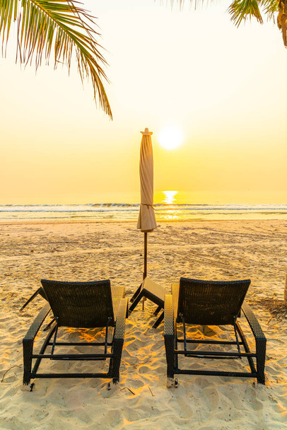 spiaggia di ombrelloni con palma e spiaggia al sorgere del sole - concetto di vacanza e vacanza - Foto, immagini