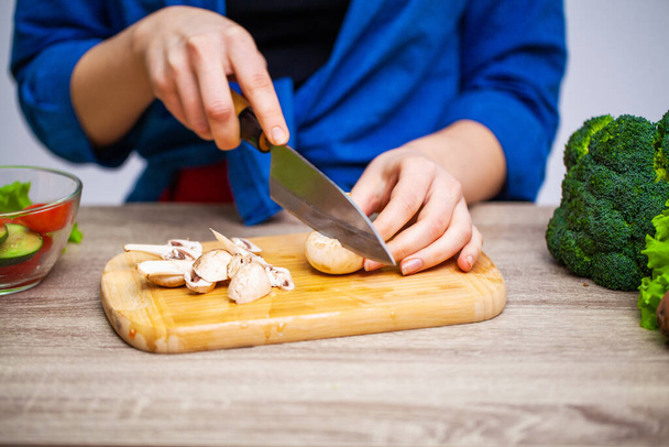 Käsitys terveellisestä ruokavaliosta, nainen leikkaa tuoreita vihanneksia salaattiin
 - Valokuva, kuva