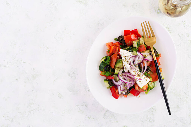 Модный салат. Греческий салат со свежими овощами, сыром фета и черными оливками. Здоровое сбалансированное питание. Вид сверху, навес, плоский
 - Фото, изображение