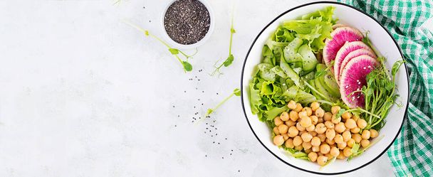 Moda salatası. Nohut, karpuz turpu, salatalık ve bezelye filizli vejetaryen Buda kasesi. Sağlıklı dengeli beslenme. Üst görünüm, genel görünüm, afiş - Fotoğraf, Görsel