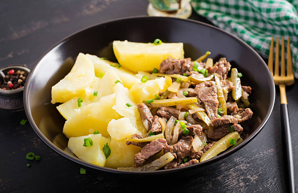 Stew beef, pieces of beef stewed with pickled cucumber in russian style. Beef stroganoff and boiled potatoes. - Photo, Image