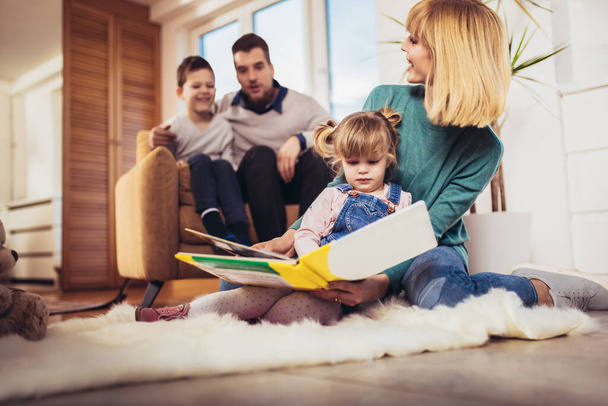 Glückliche Familie, die sich auf dem Fußboden oder im Wohnzimmer zu Hause amüsiert und lacht. Selektiver Fokus. - Foto, Bild