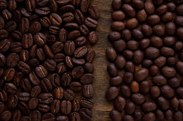 Granos de café derramados sobre madera oscura, asados, marrones. Agrupado por reverso y anverso
. - Foto, imagen