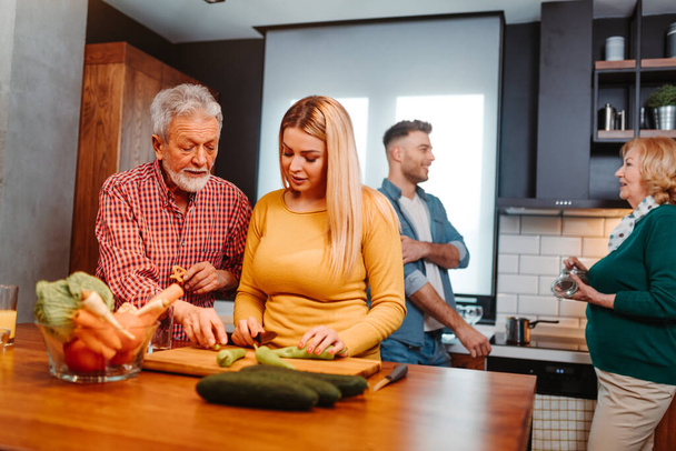 Apa és lánya zöldséges salátát csinálnak együtt a konyhában.. - Fotó, kép