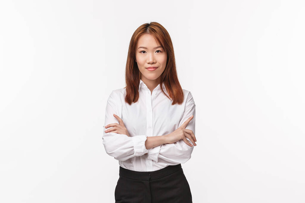Professionals, career and business concept. Serious-looking determined successful female entrepreneur in white collar shirt, cross hands chest self-assured, smiling and looking camera confident - Photo, Image