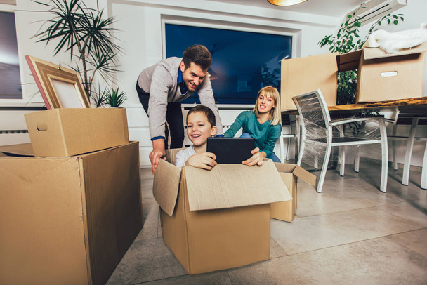 Щаслива сім'я переїжджає додому з коробками навколо
 - Фото, зображення