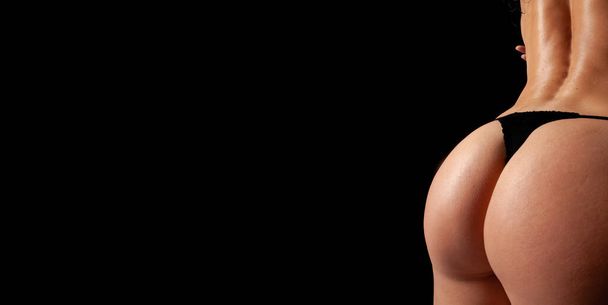 Studio photo of a model on a black background, Fitness for a healthy lifestyle, Beautiful ass, sculpted muscles, lack of subcutaneous fat or its minimum, - 写真・画像