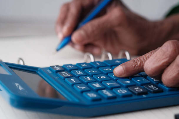 les femmes âgées utilisent la calculatrice et l'écriture sur le bloc-notes
  - Photo, image
