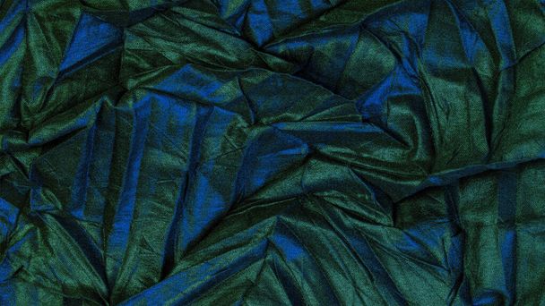 textuur. achtergrond. patroon. behang. zwarte zijde stof met blauwe smaragdgroene strepen, gerimpelde stof - Foto, afbeelding