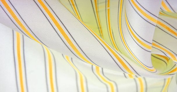 relief drawing, composite textiles, dense silk fabric of white color, yellow, amber, golden and gray lines, a stroke on the fabric, a narrow strip. feature, line, stroke, dash, trace, - Photo, Image